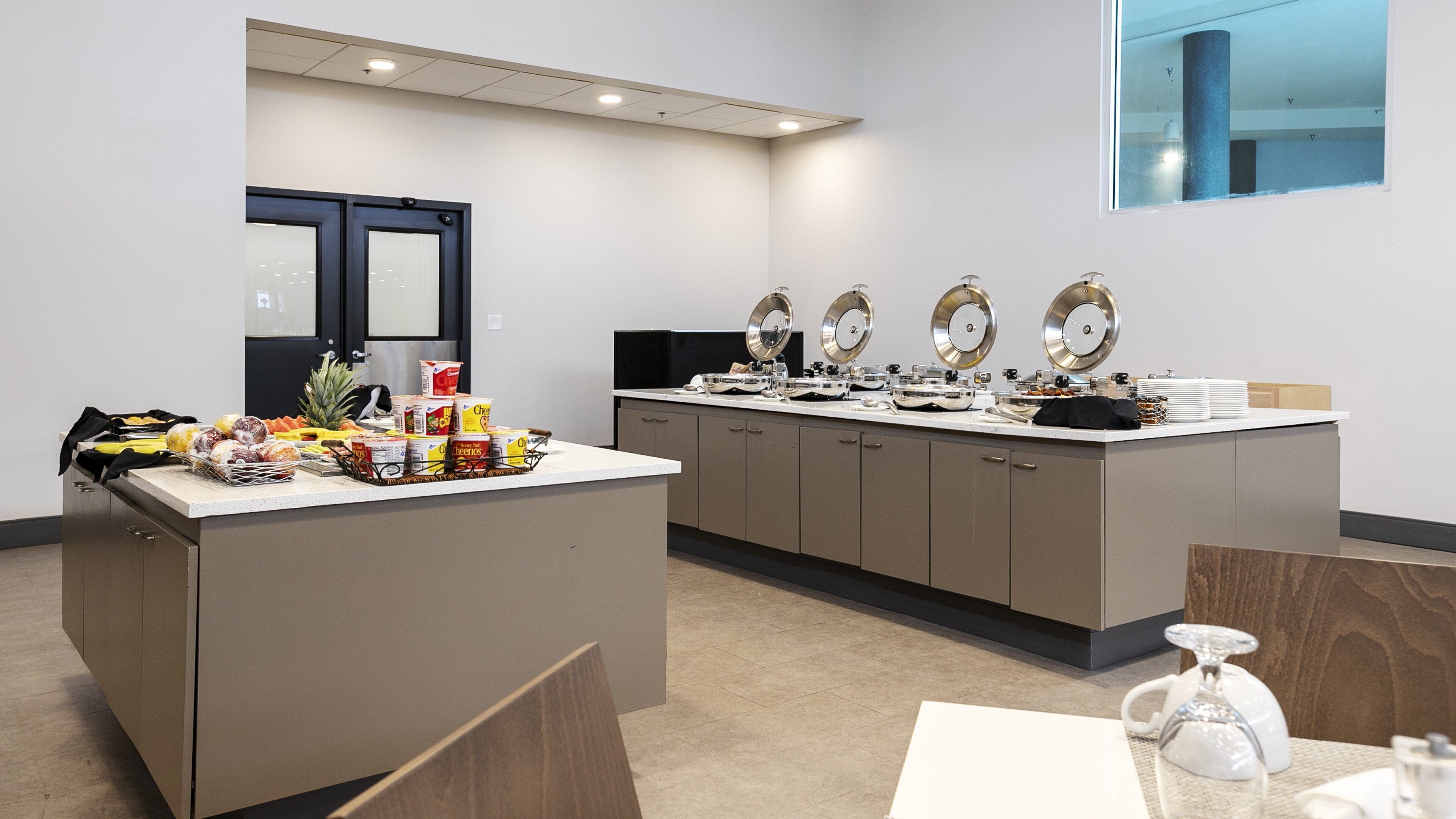 Habitación de hotel con kitchenette, comedor y un amplio ventanal.