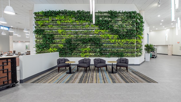 A modern lobby with a green vertical garden wall, seating area with chairs and tables, and a reception desk. - Holiday Inn Panama City by IHG (Panama City)