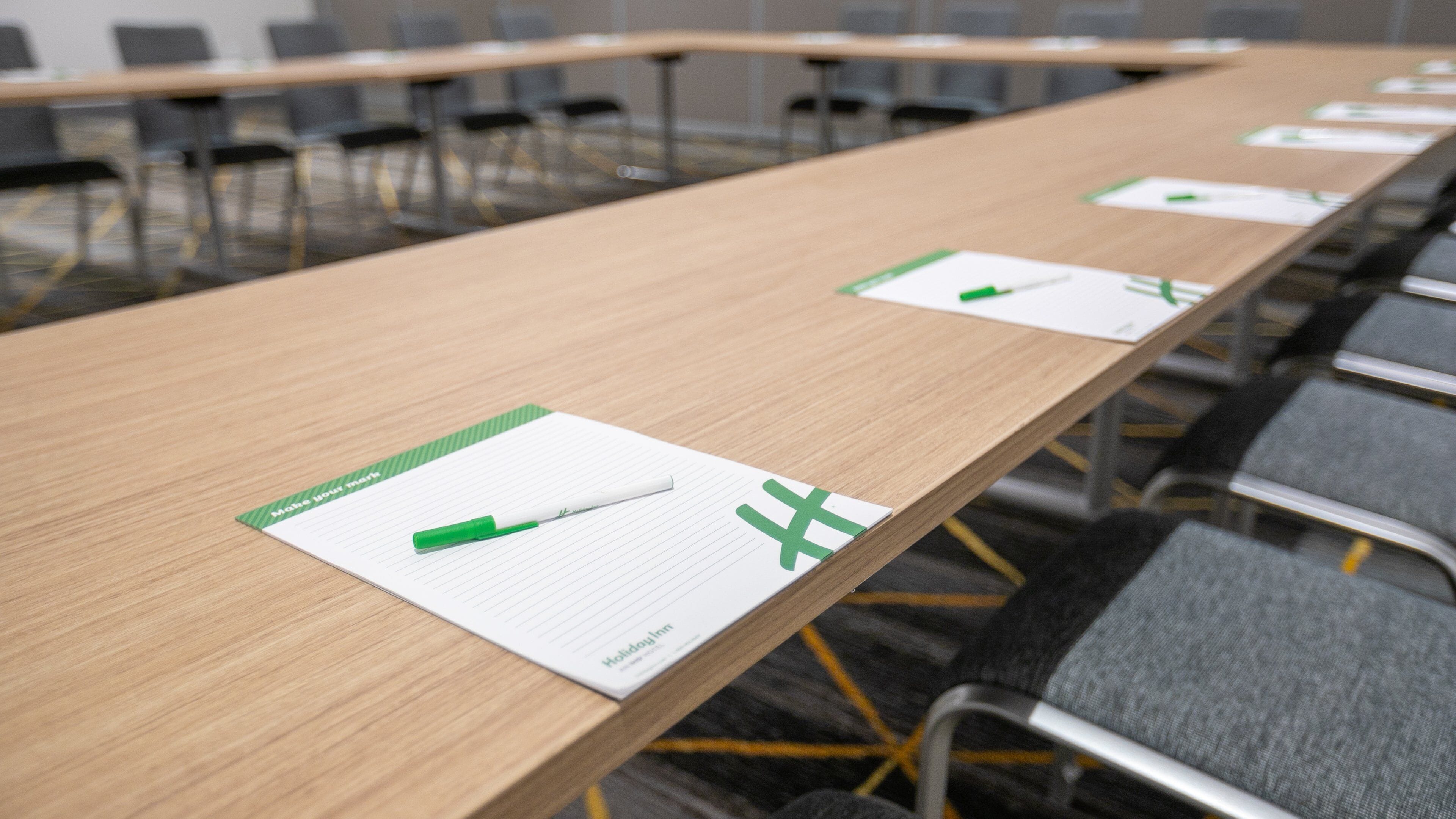 A conference room with a long table, lined with chairs, and name cards on the table.