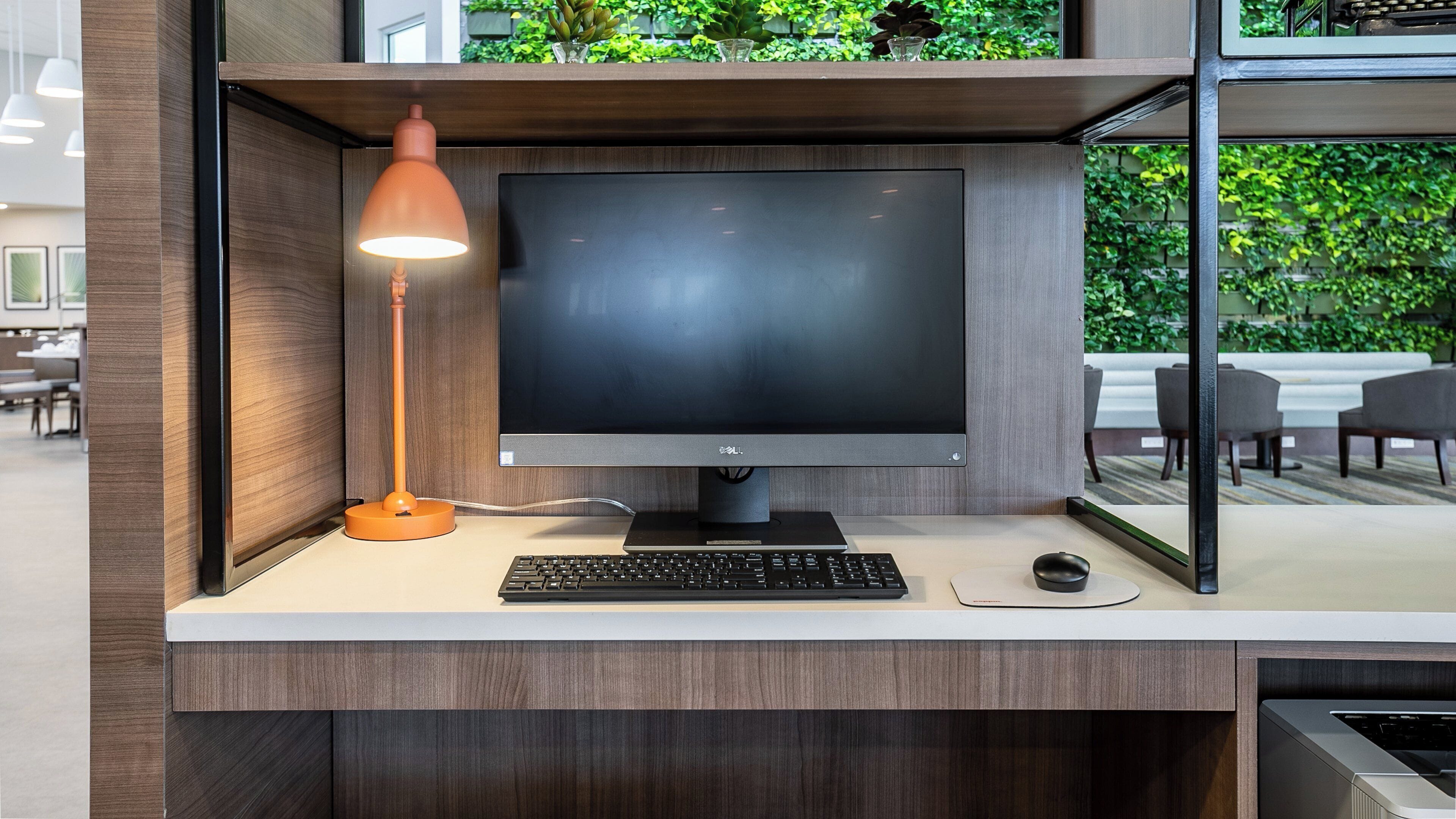 Un bureau moderne équipé d’un ordinateur, d’un clavier, d’une souris, d’une lampe et d’un écran.