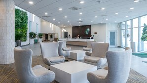 A modern lobby with a reception desk, seating area, and a green wall with plants. - Holiday Inn Panama City by IHG (Panama City)