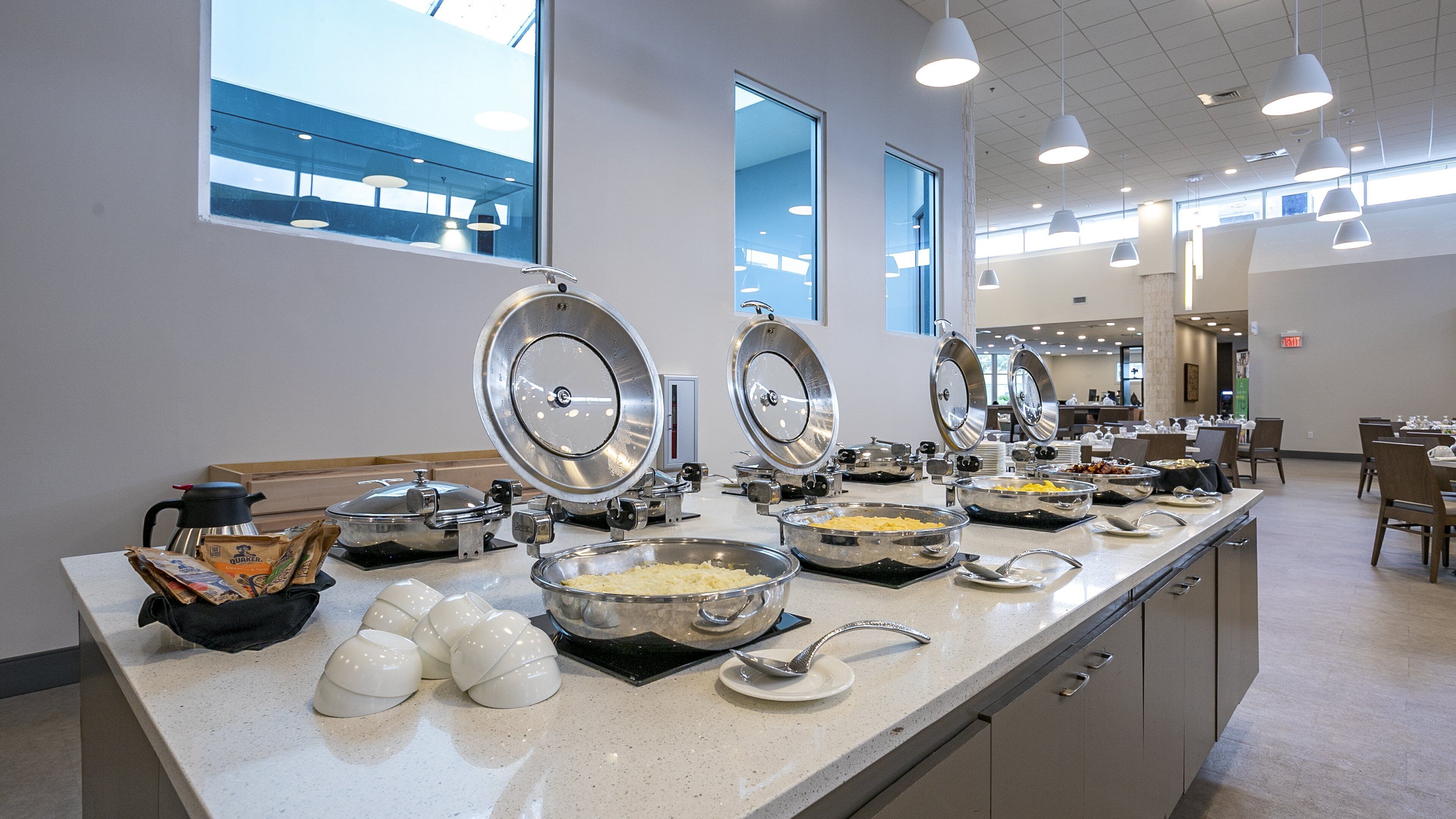 A buffet setup with multiple serving stations, including bowls of food and utensils.
