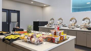 A buffet setup with various food items and condiments.