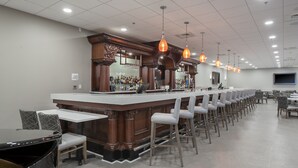 A bar area with a long counter, multiple bar stools, and a seating area with tables and chairs. - Holiday Inn Panama City by IHG (Panama City)