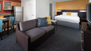 A hotel room with a sofa, a bed, a TV, a desk with a chair, and a kitchen area with a refrigerator. - Residence Inn by Marriott Costa Mesa Newport Beach (Costa Mesa)
