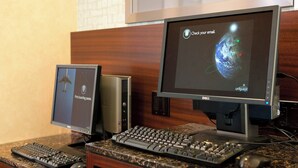 Two monitors, a keyboard, and a mouse on a desk with a wooden panel and a granite countertop. - Residence Inn by Marriott Costa Mesa Newport Beach (Costa Mesa)