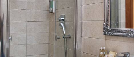 A modern bathroom with a glass-enclosed shower, a white sink, and a large mirror.