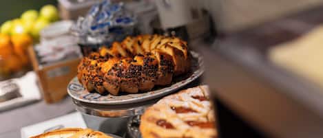 A variety of baked goods on display, including a braided bread and a pie, suggesting a bakery or café setting.