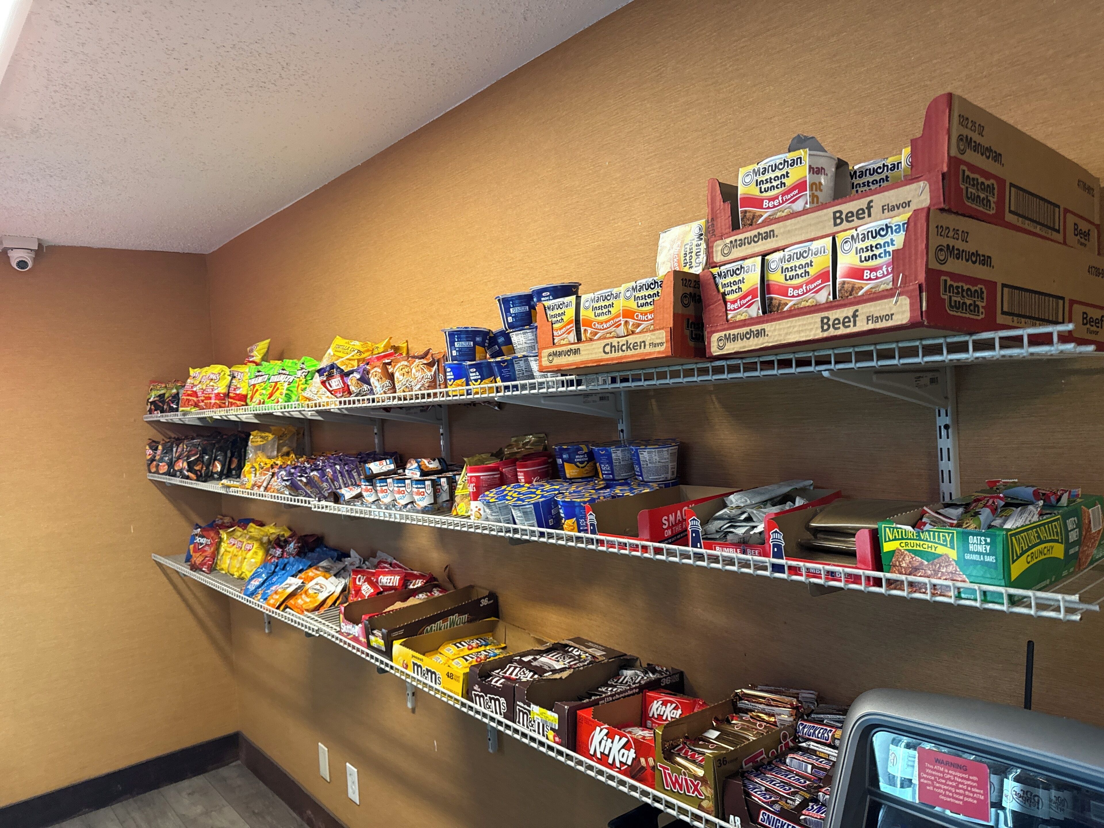 A snack aisle with various packaged snacks and instant meals.