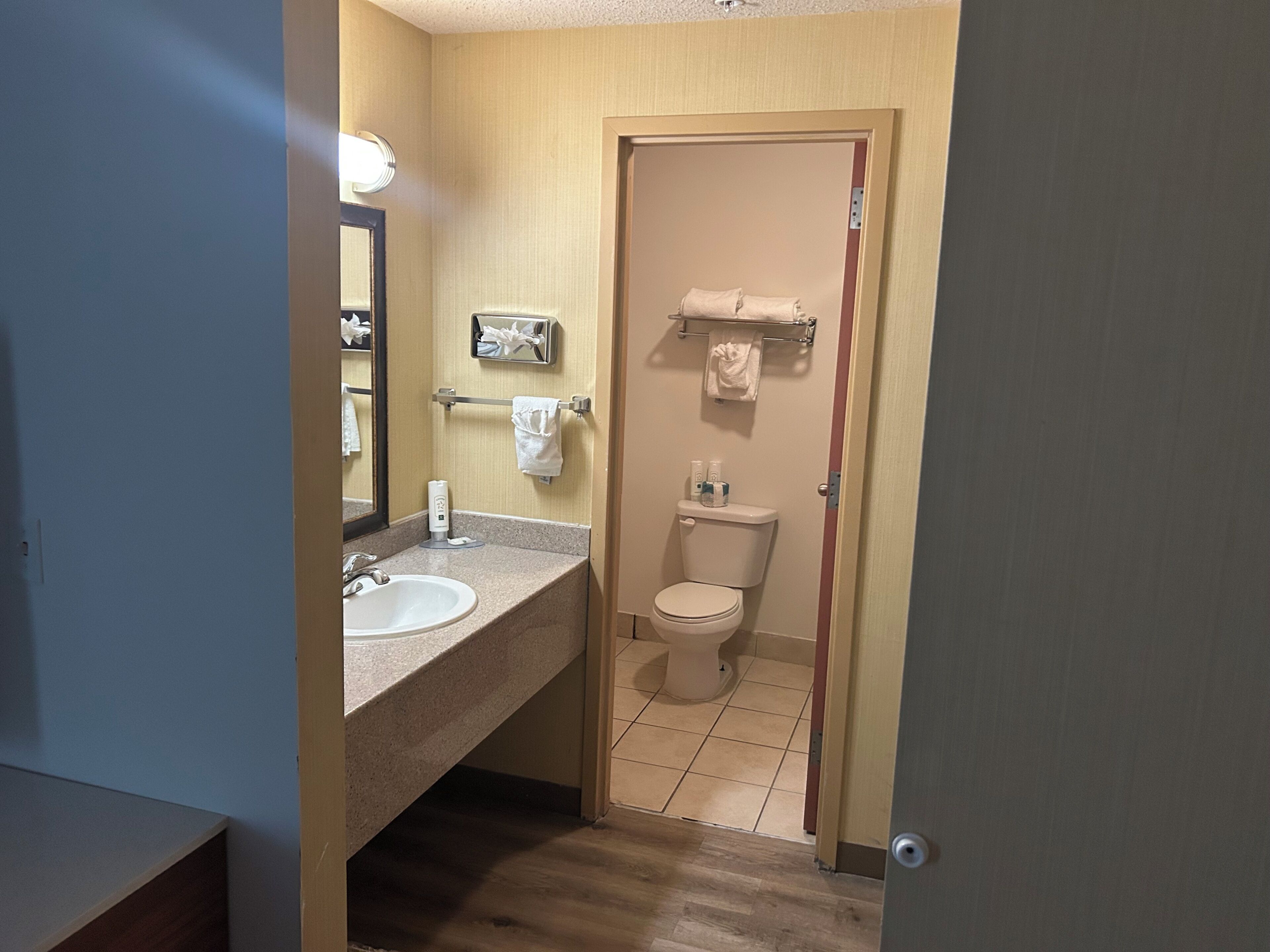 A bathroom with a sink, toilet, and hand dryer.
