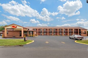 A motel with a central parking area, a drive-through, and a building with a red roof and multiple windows. - Econo Lodge Nashville North (Nashville)