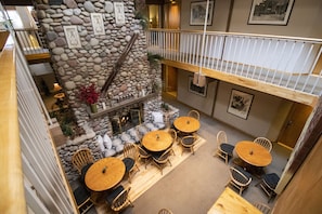A multi-level interior with stone walls, wooden furniture, and a balcony.