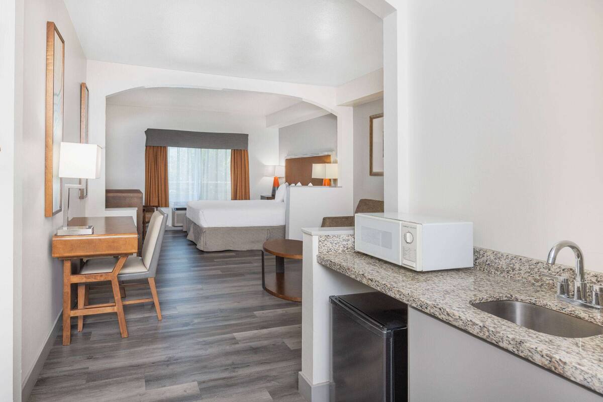 Ein Hotelzimmer mit Küchenzeile, Essbereich und einem Bett.