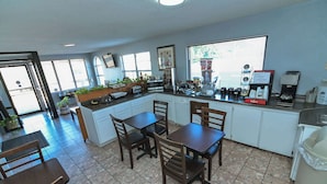 A compact kitchen with a dining area, equipped with a microwave, toaster, coffee maker, and a sink. - Americas Best Value Inn Meridian (Meridian)