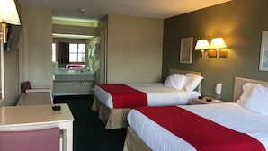 A hotel room with two beds, a desk, a chair, a mirror, and a bathroom visible through an open door. - Americas Best Value Inn Meridian (Meridian)