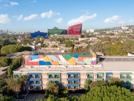 Un hotel con varios pisos, zonas de estar al aire libre y vistas a la ciudad.
