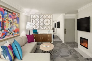 A modern living room with a sofa, coffee table, fireplace, and artwork. -  Le Parc at Melrose (West Hollywood)
