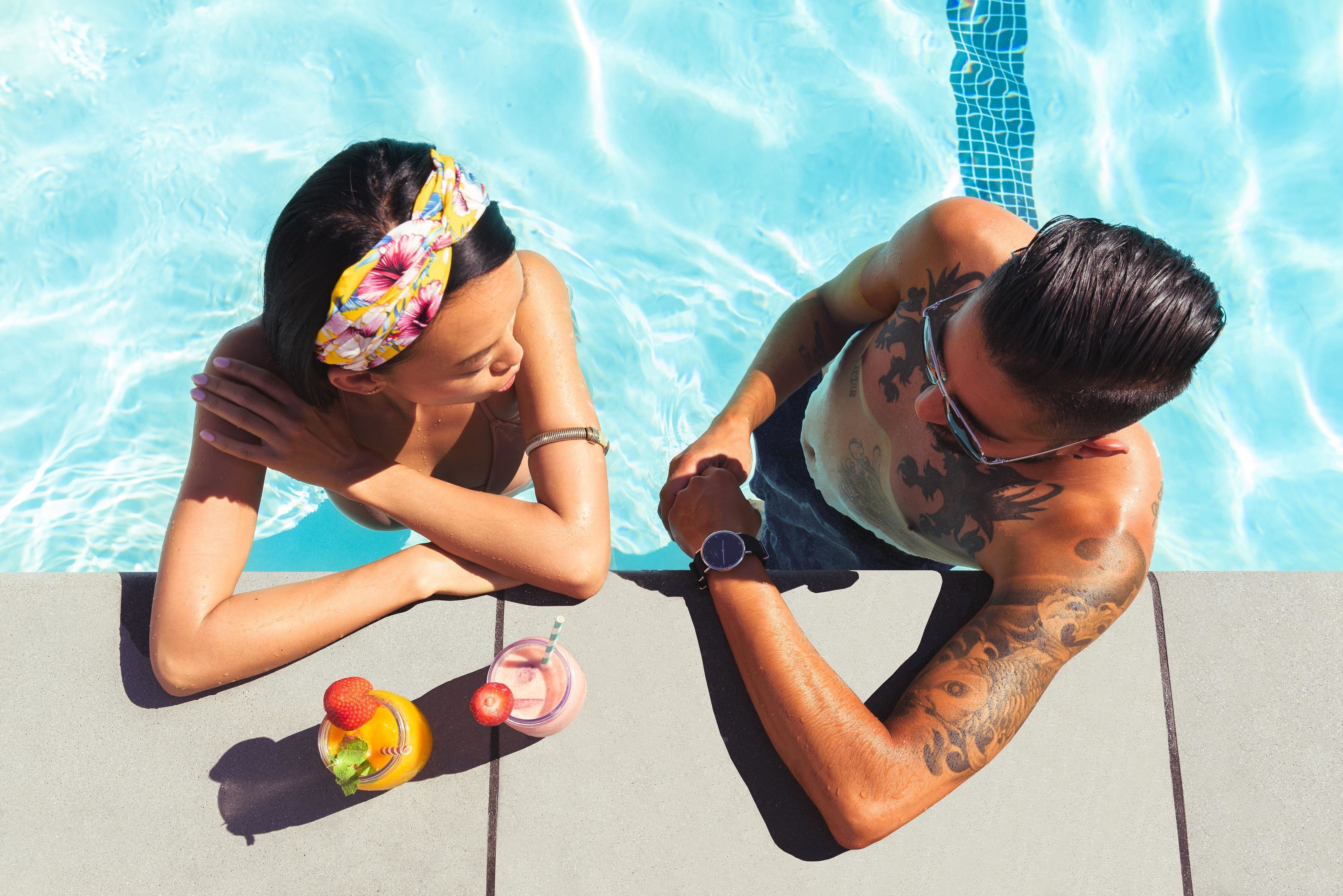 Une scène se déroulant au bord d’une piscine, avec une personne et une boisson.