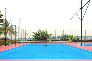 Enjoy a game of tennis on our outdoor court, surrounded by lush greenery and comfortable benches.
