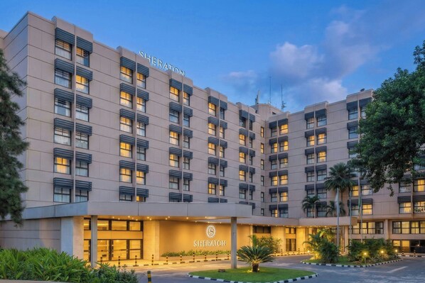 A Sheraton hotel with a modern facade, multiple balconies, and a well-lit entrance.