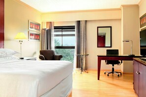 Comfortable room with a large bed, desk, and television.