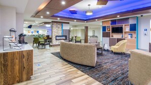 A modern lobby with a reception desk, seating area, and a TV screen. - Comfort Inn & Suites Pittsburgh Fox Chapel (Pittsburgh)