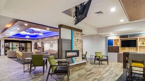 A modern lobby with a fireplace, seating area, and a TV. - Comfort Inn & Suites Pittsburgh Fox Chapel (Pittsburgh)