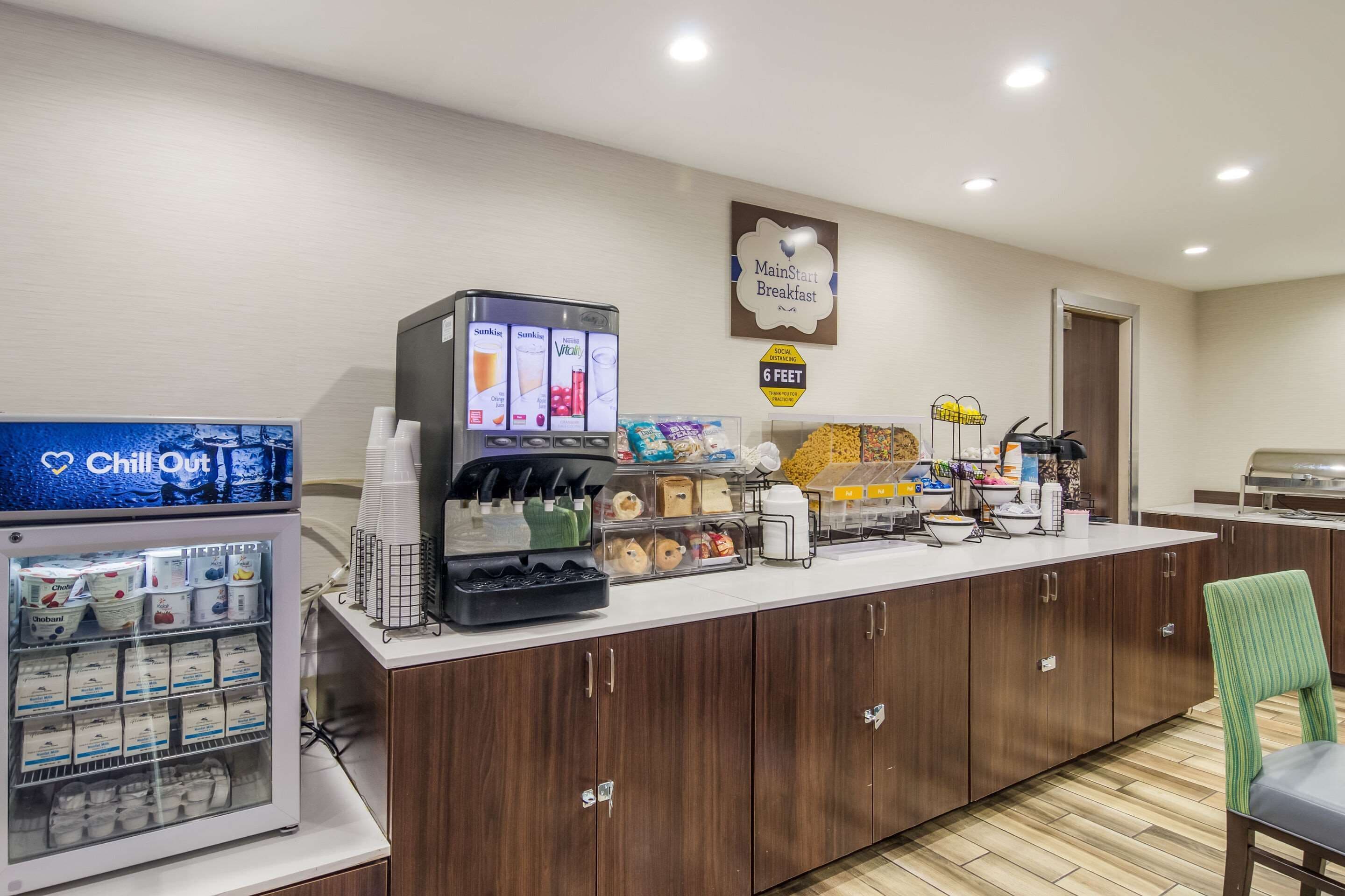 A breakfast area with a vending machine, a refrigerator with milk cartons, and a coffee station.