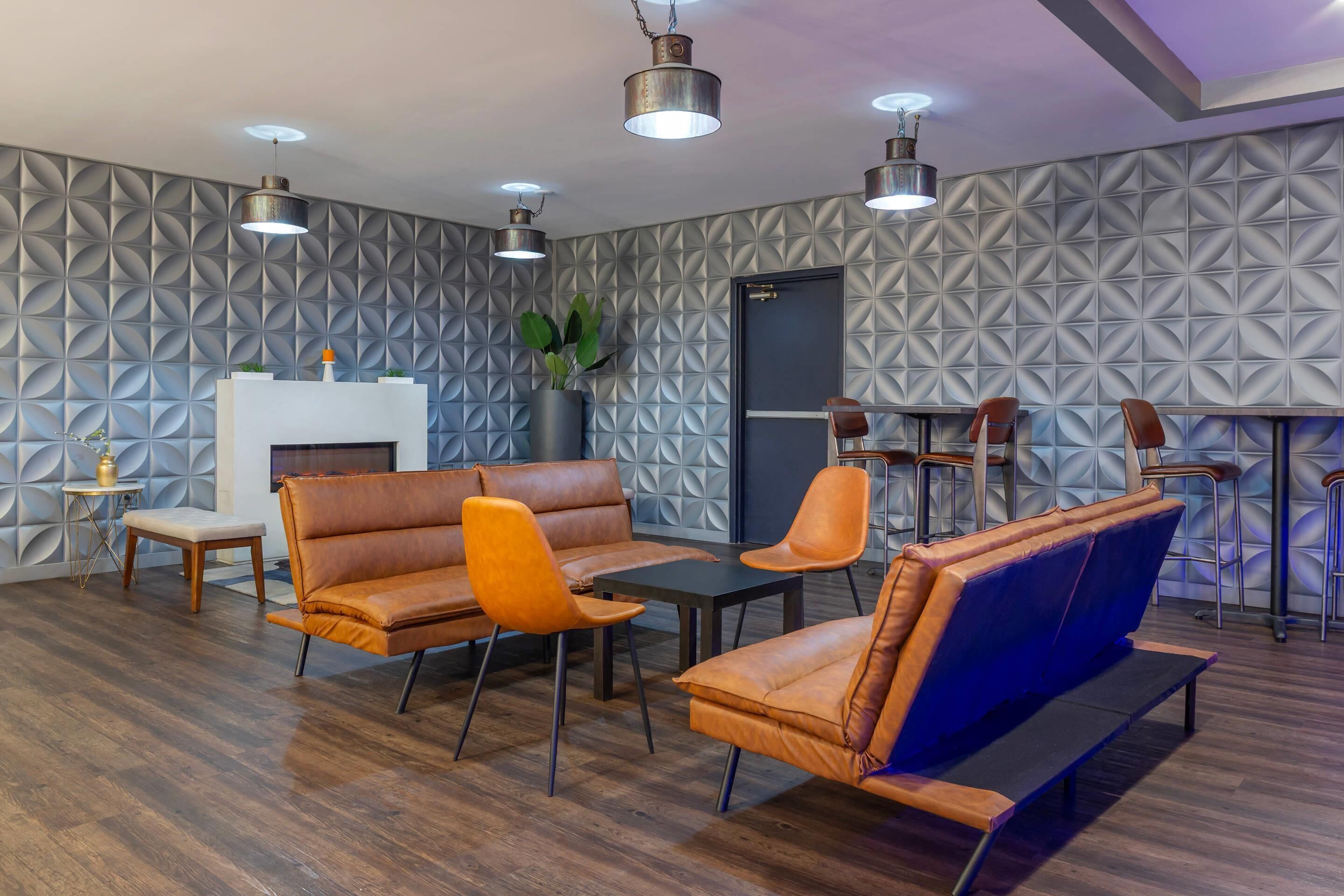 A modern lounge area with leather sofas, a coffee table, and a fireplace.