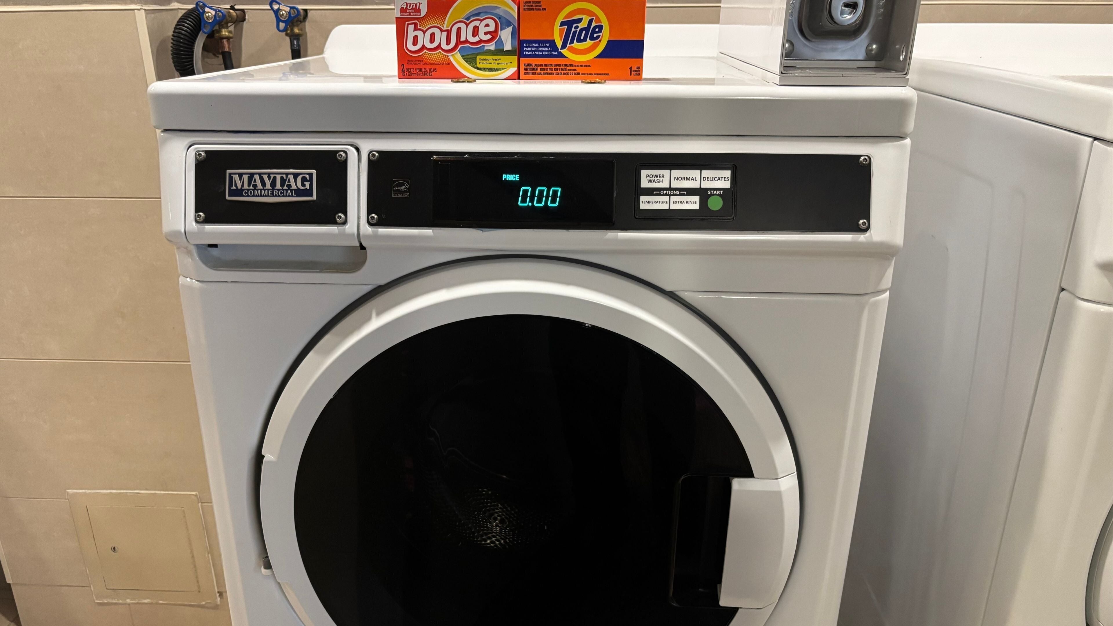 A Maytag commercial washer with a digital price display and control panel.