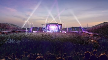 Een groot openluchtpodium met een podium en publiek.