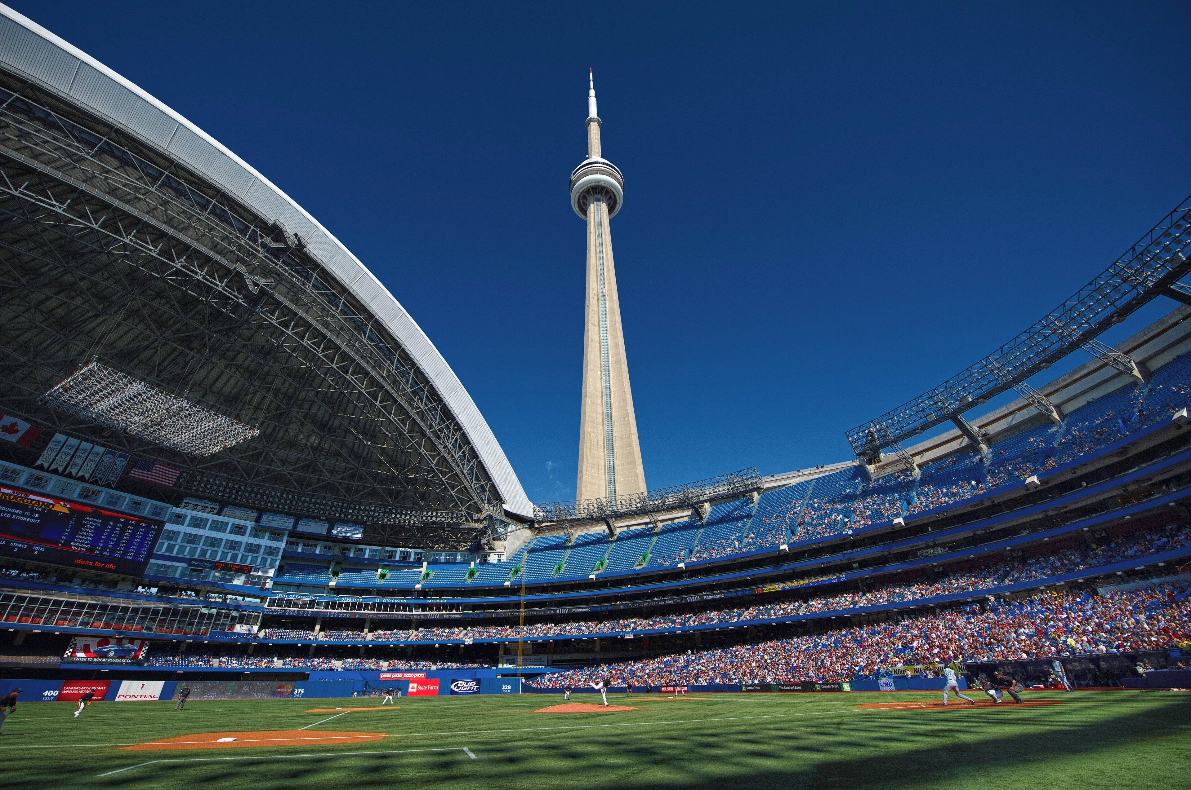 A large stadium with multiple tiers of seating and a prominent tower in the background.