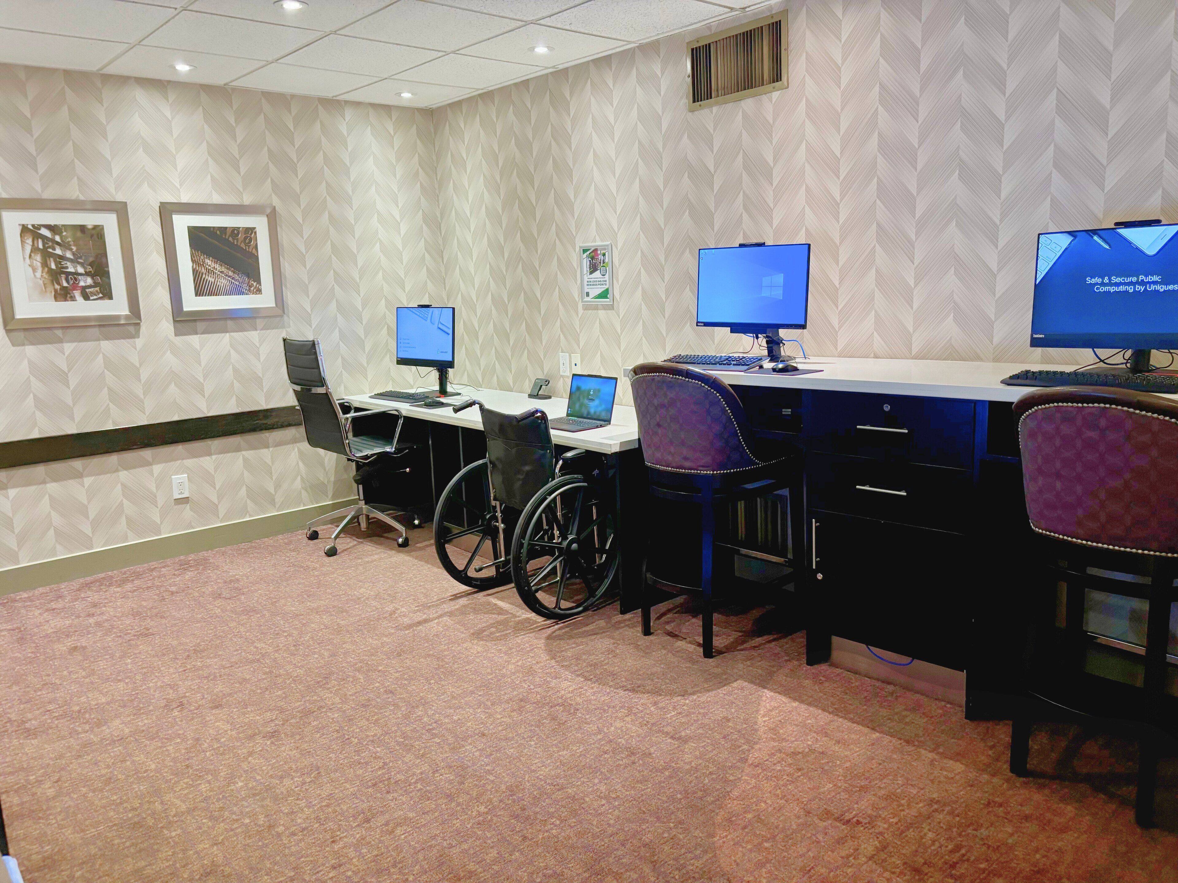 Une salle de conférence équipée de plusieurs postes de travail, notamment d’ordinateurs portables et de bureau, de chaises ergonomiques et d’un sol recouvert de moquette.