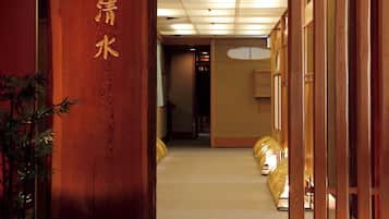 A traditional Japanese interior with a wooden entrance, tatami mat flooring, and a reception desk.