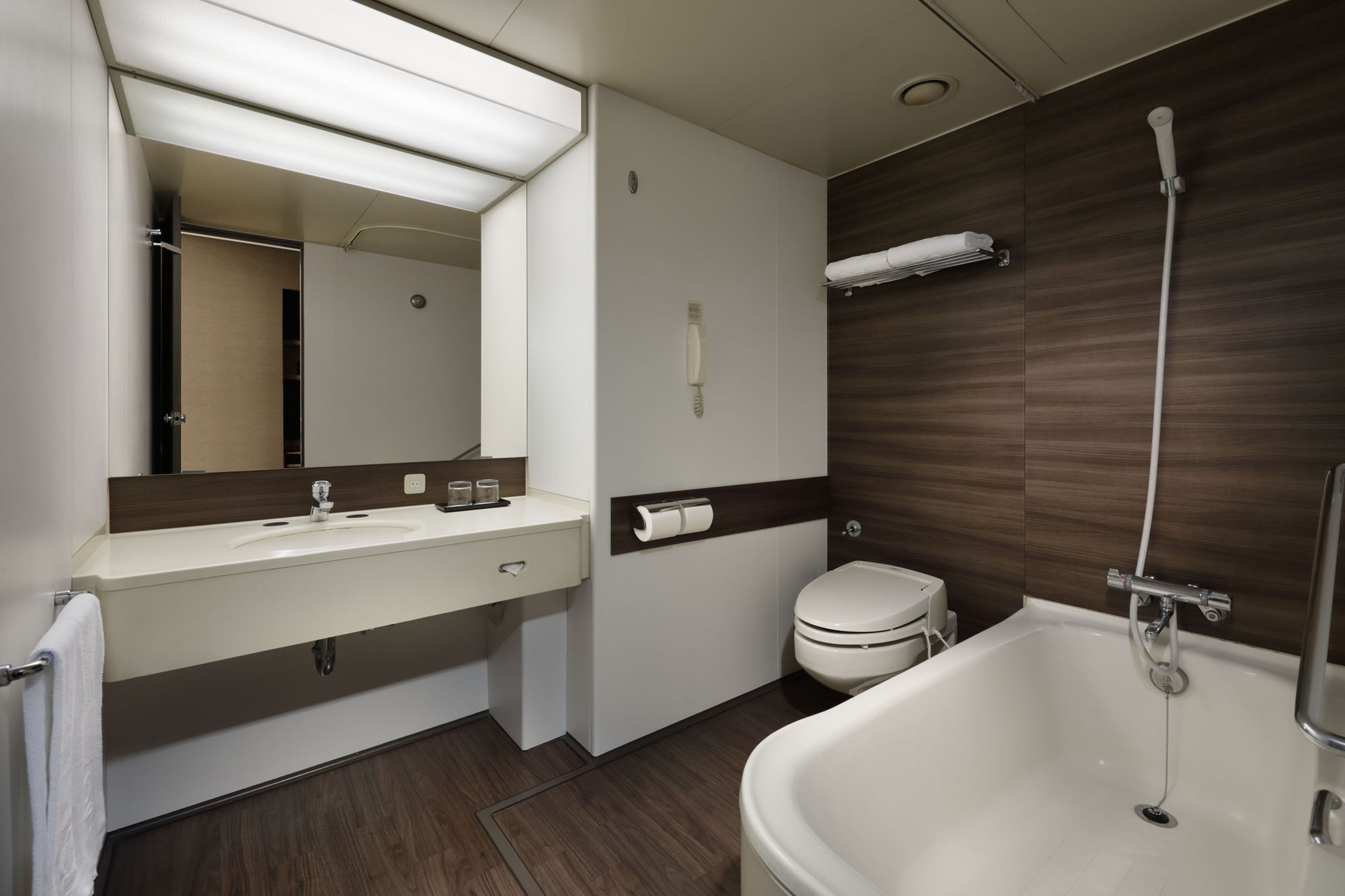 A modern bathroom with a sink, toilet, and bathtub.