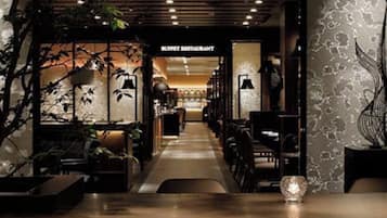 A restaurant interior with a long counter, tables, and chairs.