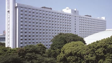 A large, modern hotel with a grid of windows and a prominent cylindrical structure on the left.