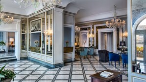 A grand lobby with marble flooring, large chandeliers, and classic furniture. - Grand Hotel Santa Lucia (Naples)