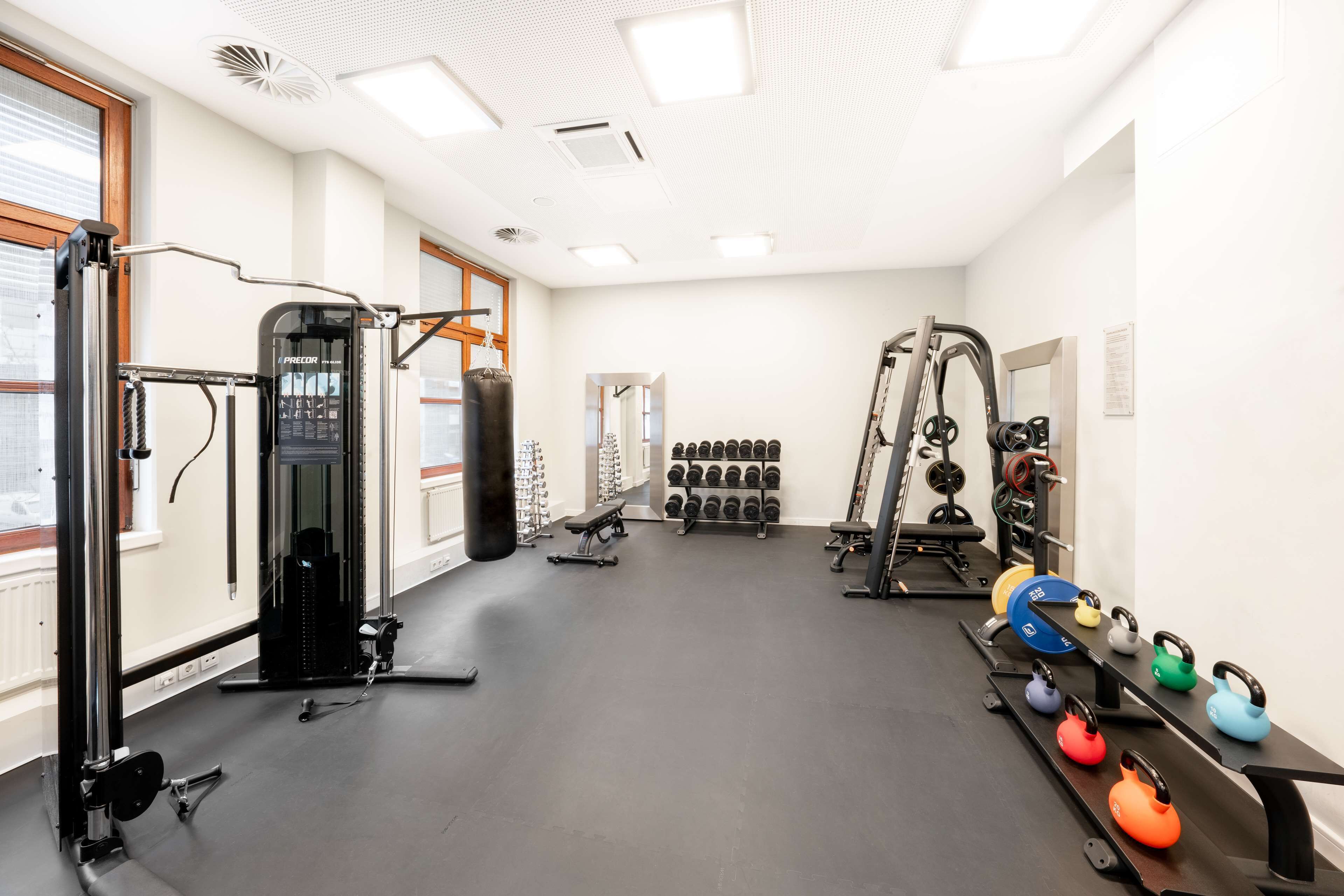 Ein Fitnessstudio mit Krafttrainingsgeräten, Kurzhanteln und Kettlebells.