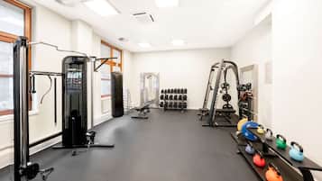 Ein Fitnessstudio mit Krafttrainingsgeräten, Kurzhanteln und Kettlebells.