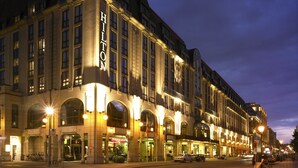 A large, historic hotel with multiple stories, prominent signage, and a well-lit facade.