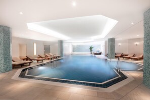 Una gran piscina coberta amb gandules i un sostre alt.