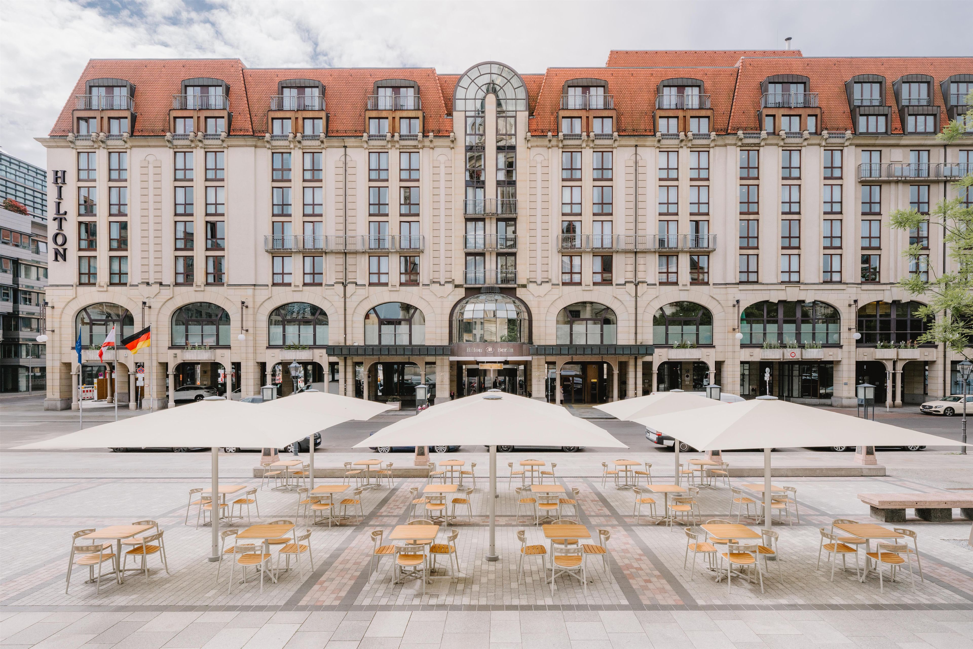 A hotel with a classic architectural style, featuring a central entrance with large glass doors and multiple balconies.