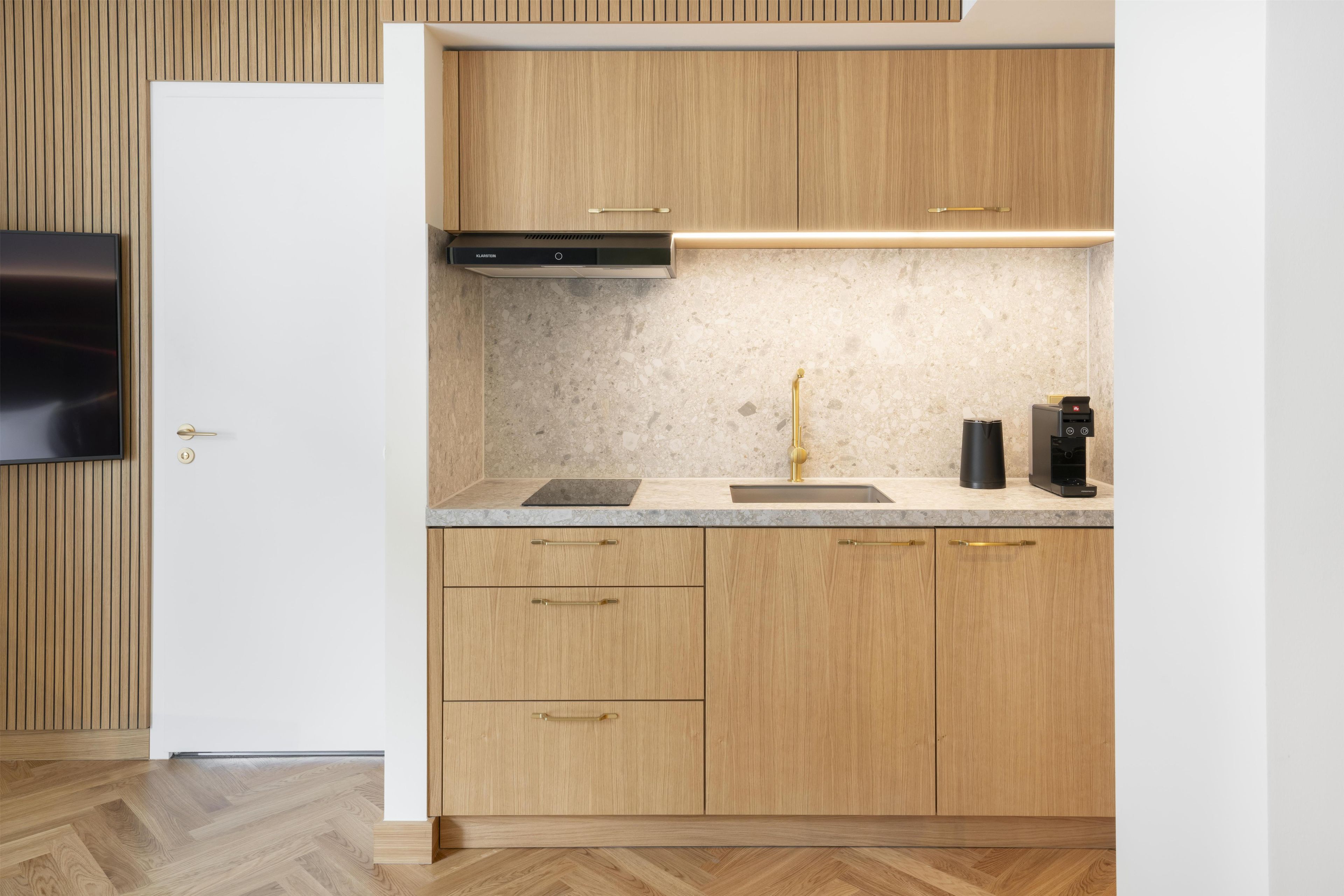 A modern kitchen with wooden cabinets, a built-in stove, a sink, and a countertop.