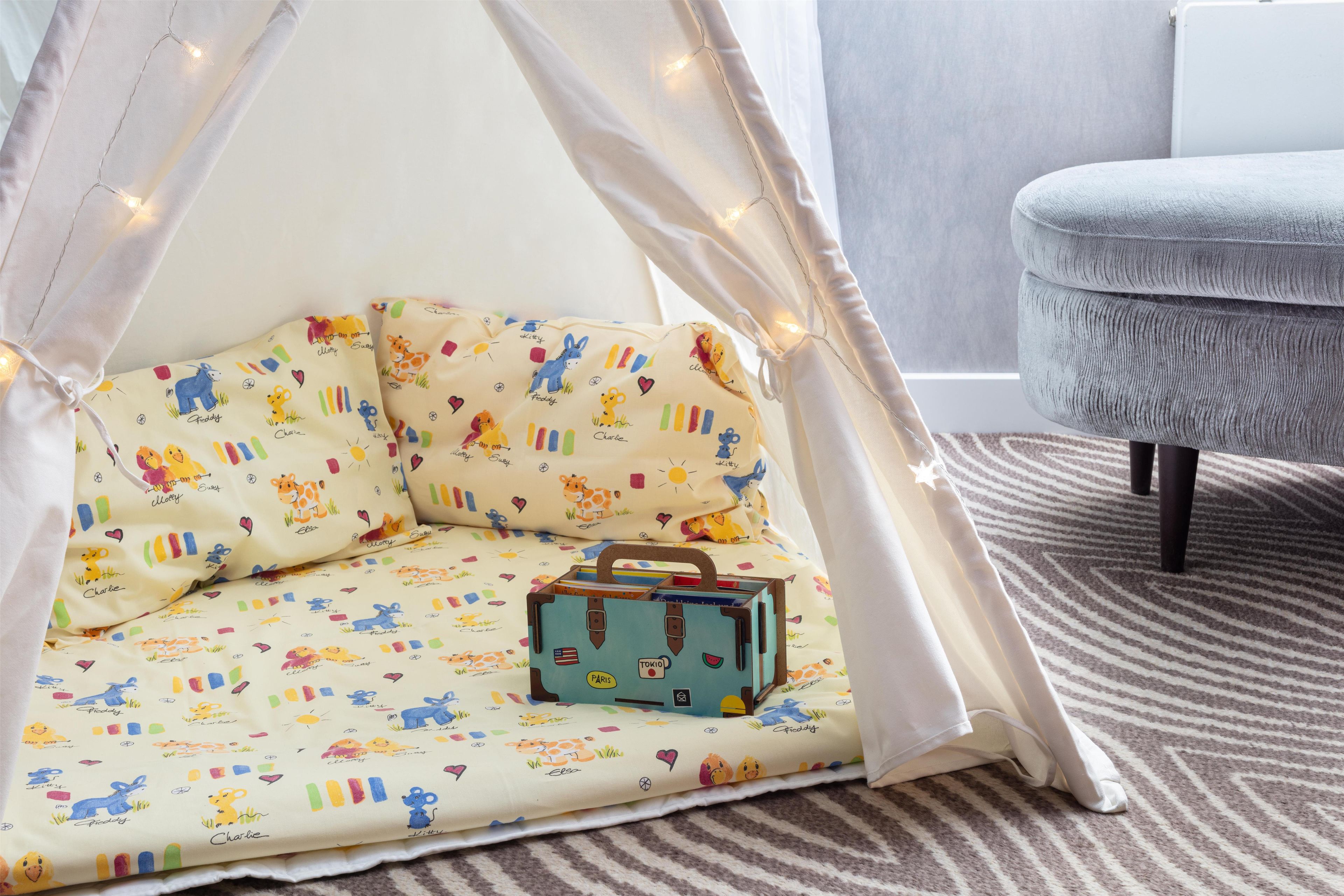 A cozy nook with a canopy, a cushioned seat, and a small blue suitcase.
