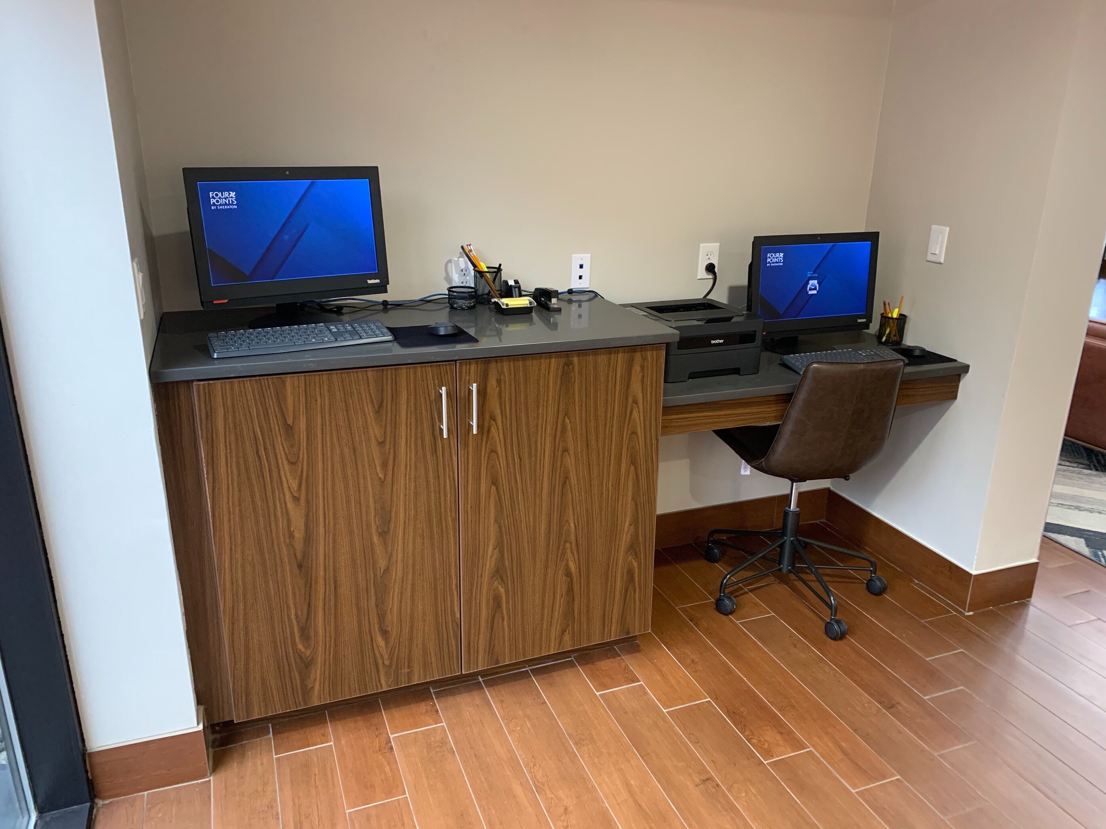 A workspace with two monitors, a keyboard, a mouse, and a chair.