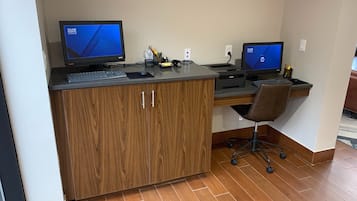 A workspace with two monitors, a keyboard, a mouse, and a chair.