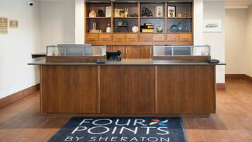 En receptionsdisk med træfinish, en sort måtte med teksten "FOUR POINTS BY SHERATON", og et "MARRIOTT BONVOY" skilt på væggen.