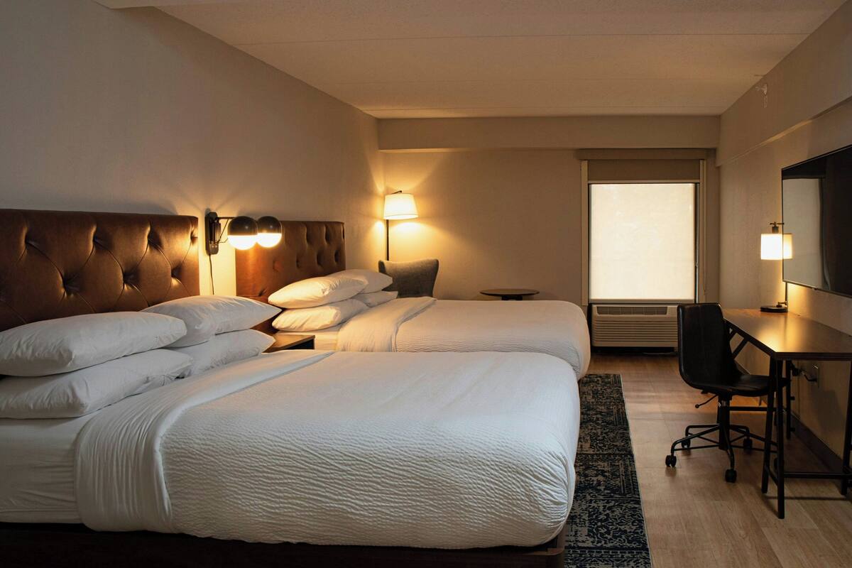 Een hotelkamer met een groot bed, een bureau en een stoel.