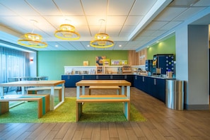 Un espace cuisine moderne doté d’un comptoir, de sièges et d’un éclairage suspendu.